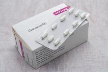 White box of gabapentin capsules with a blister pack of 10 white capsules resting on top.